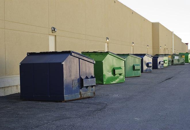 a red construction dumpster placed in front of a building under construction in Cottage Grove